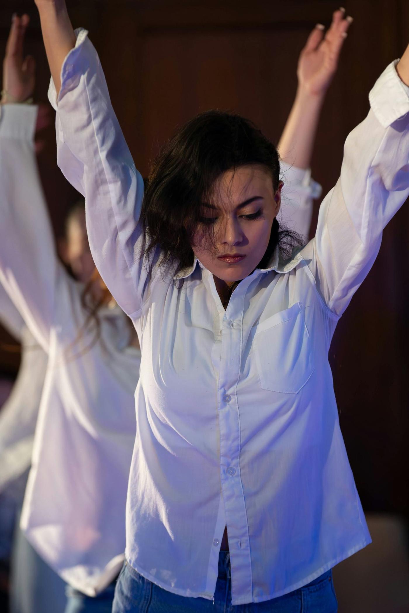 A performer with arms raised, caught mid-gesture