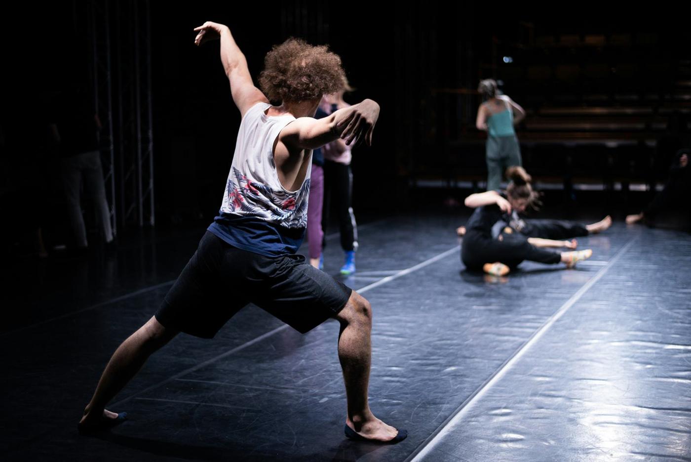 A performer leaping on a darkened stage