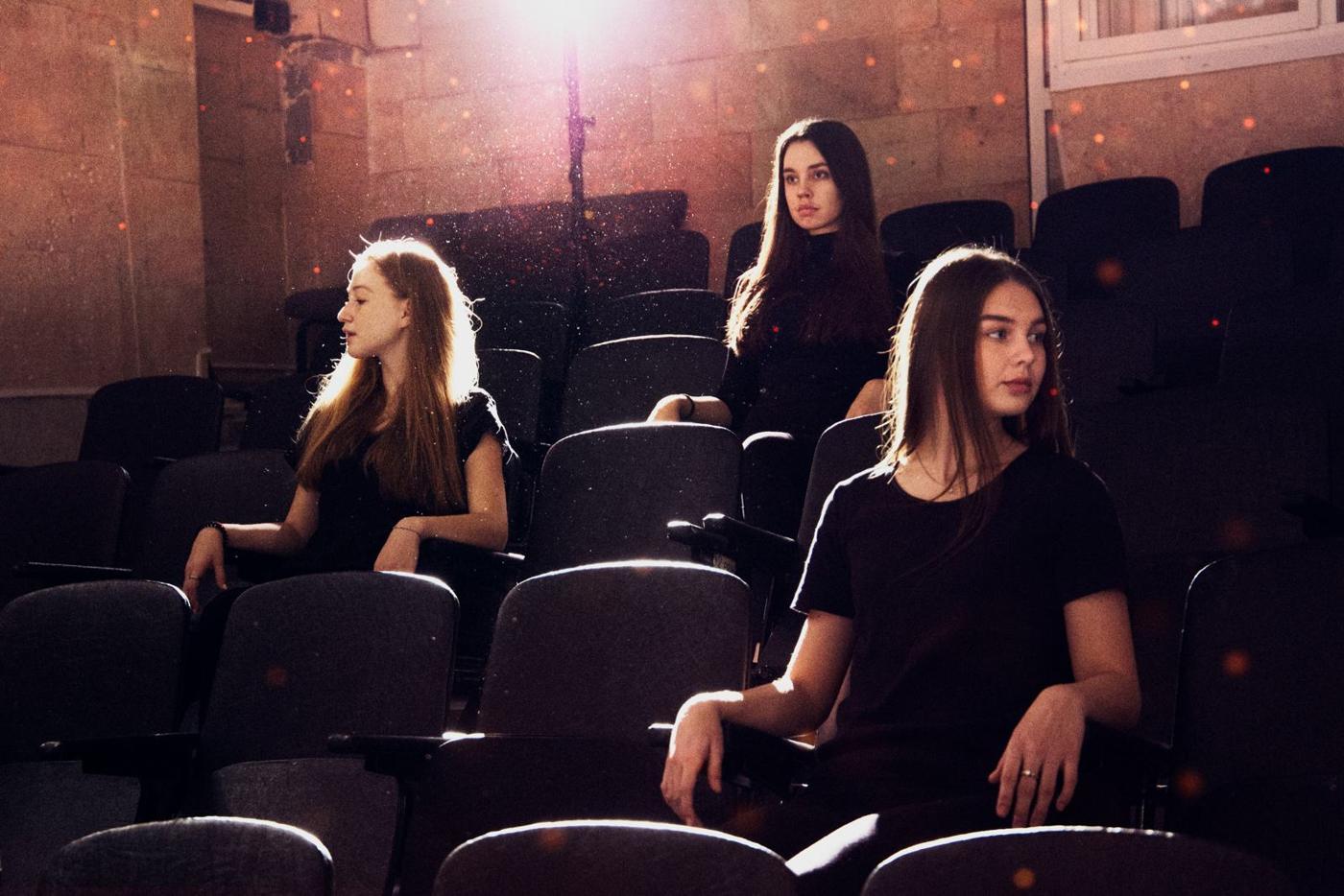 Practitioners seated in a circle in a rehearsal room, mid-discussion